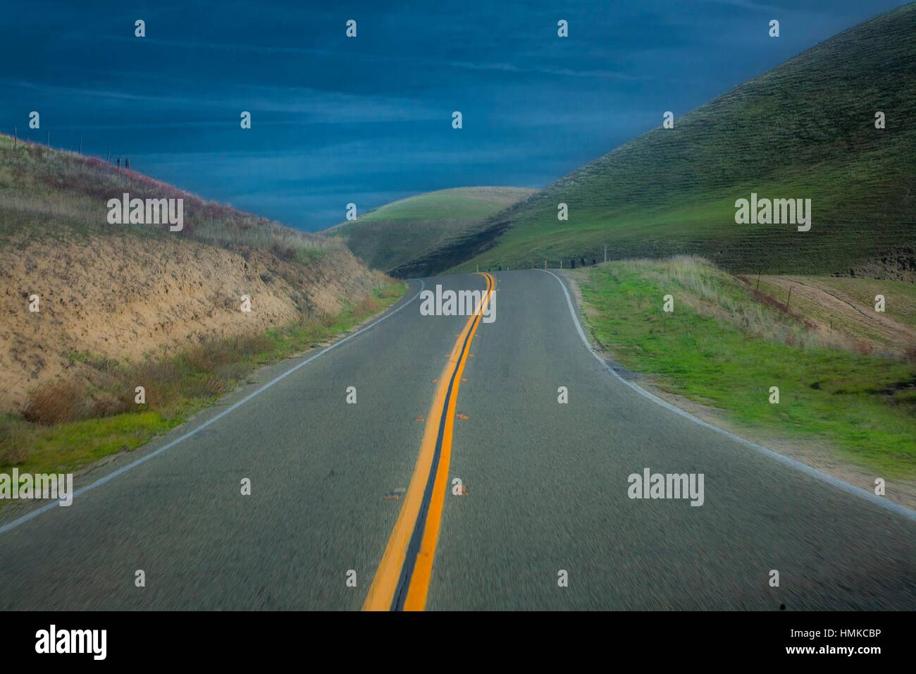 A two lane road passes through pastureland in rural California. Stock Photo
