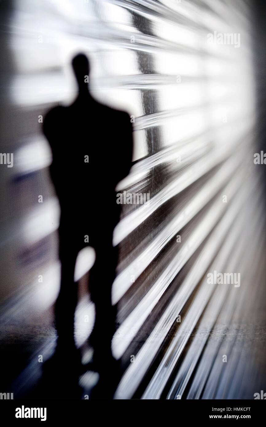 silueta de un hombre irreconocible y de incognito sobre unas sombras, silhouette of a unrecognizable and incognito man. Stock Photo
