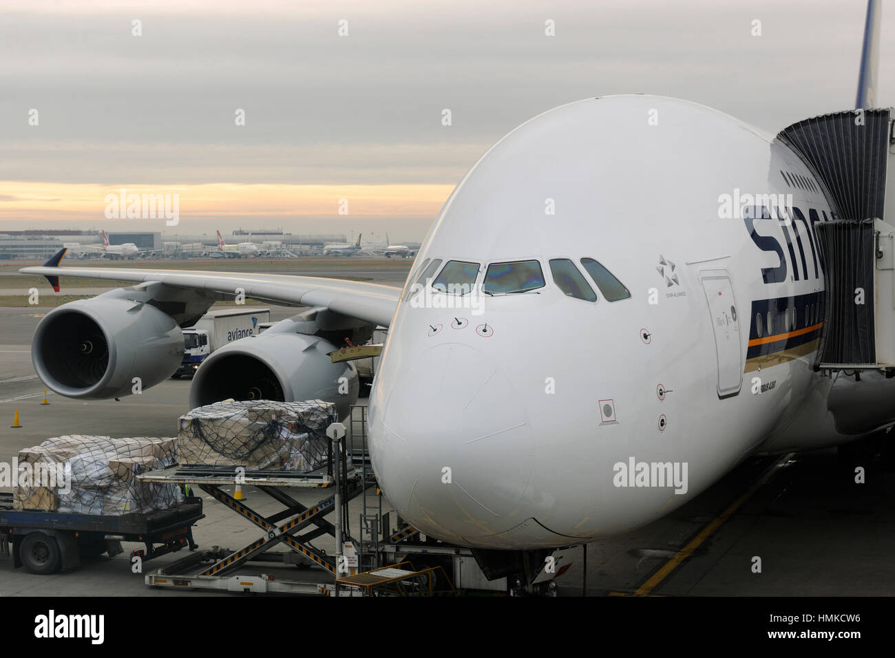 cargo being loaded from a truck and low-loader and Singapore Airlines Airbus A380-800 parked Stock Photo