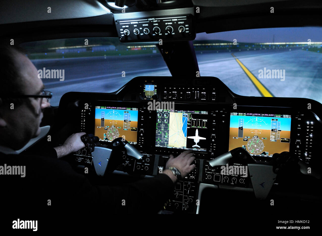 pilot in Embraer Phenom 100 cockpit-simulator CAE 5000 series at CAE Burgess Hill, UK training centre simulating taxiing at Stock Photo