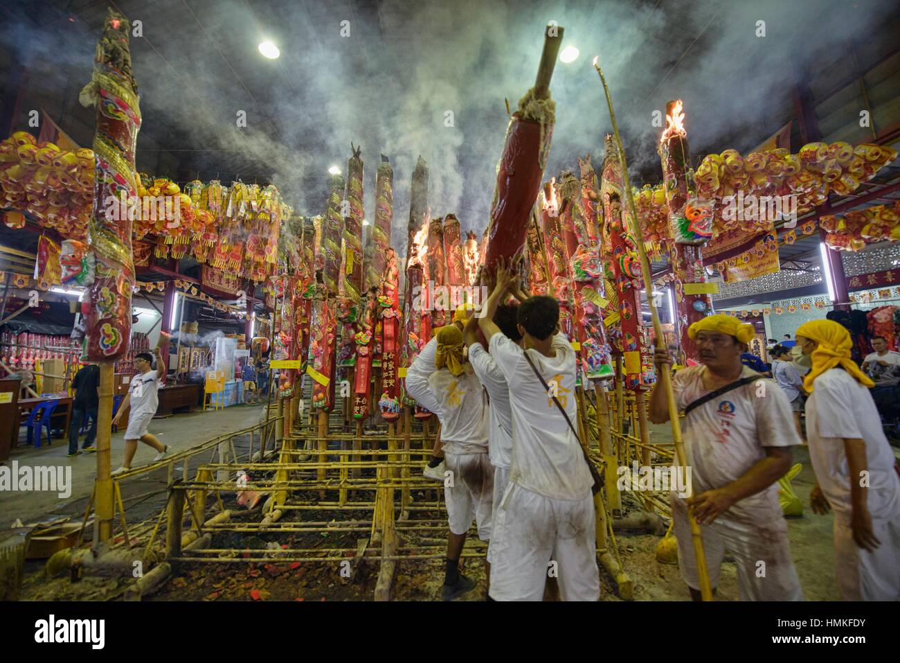 lighting prayer poles for merit and good luck at the Vegetarian