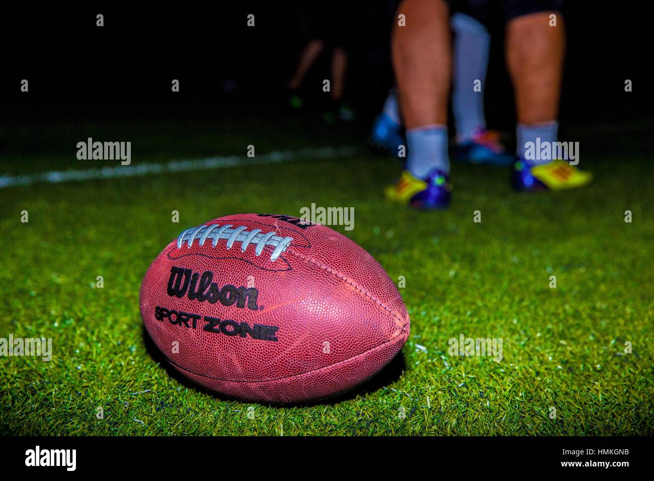 american football players with their ball lying on the green floor Stock  Photo - Alamy