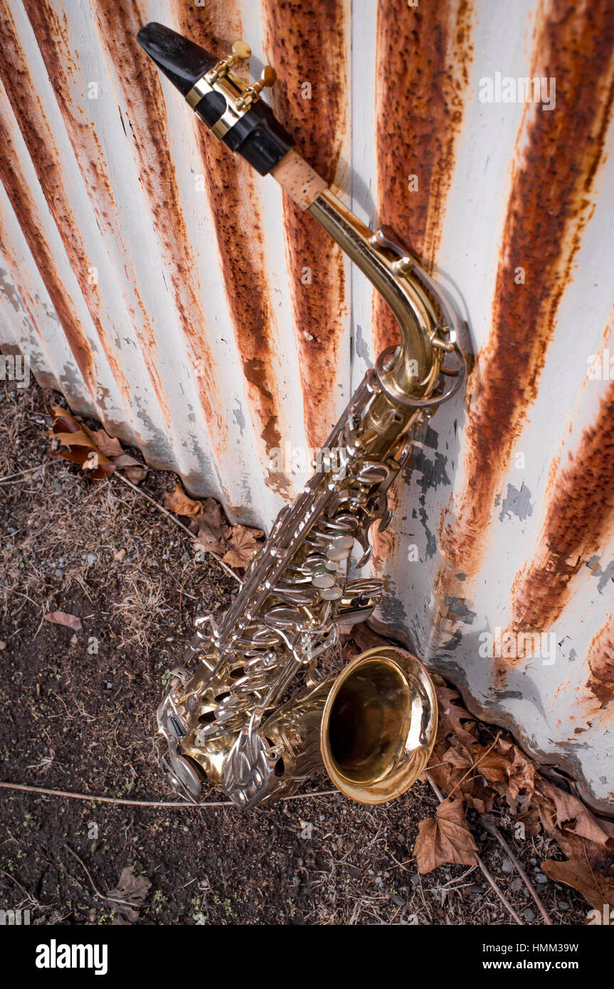 Jazz musical instrument saxophone with rusty fence background Stock