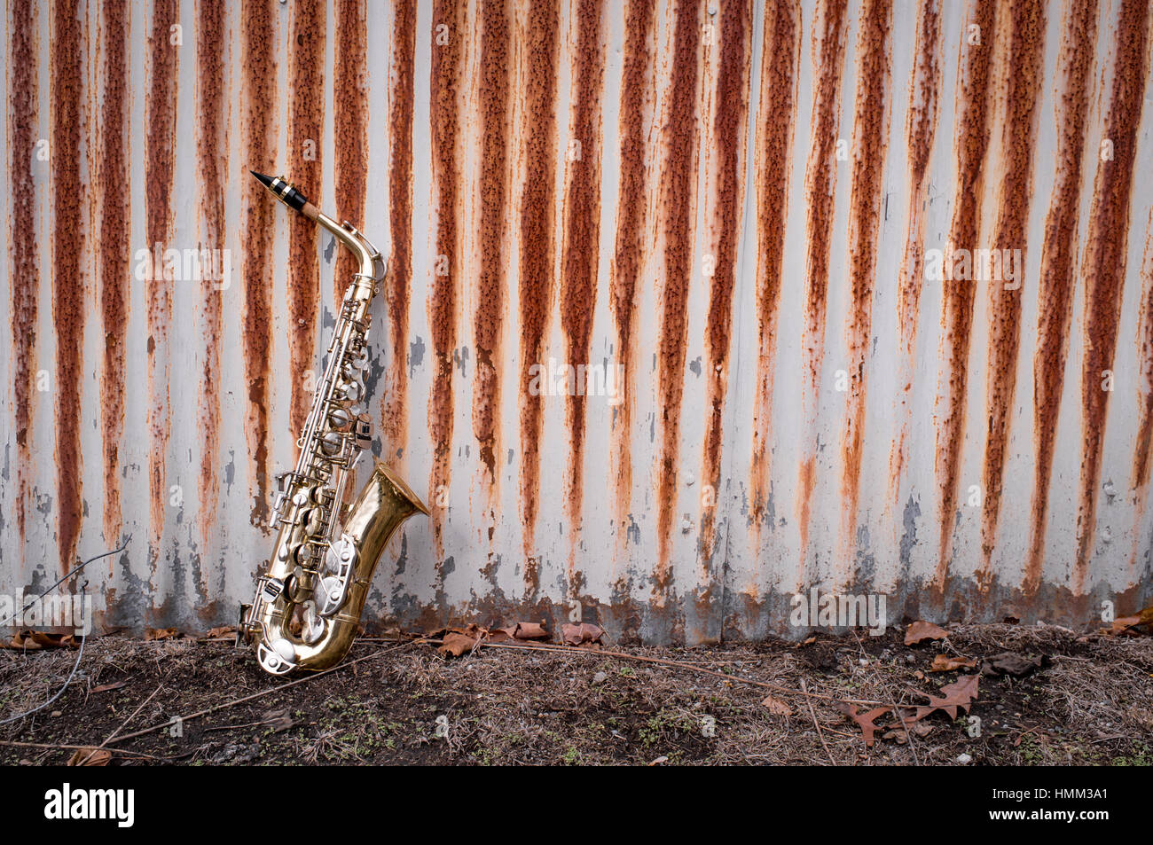 Jazz musical instrument saxophone with rusty fence background Stock