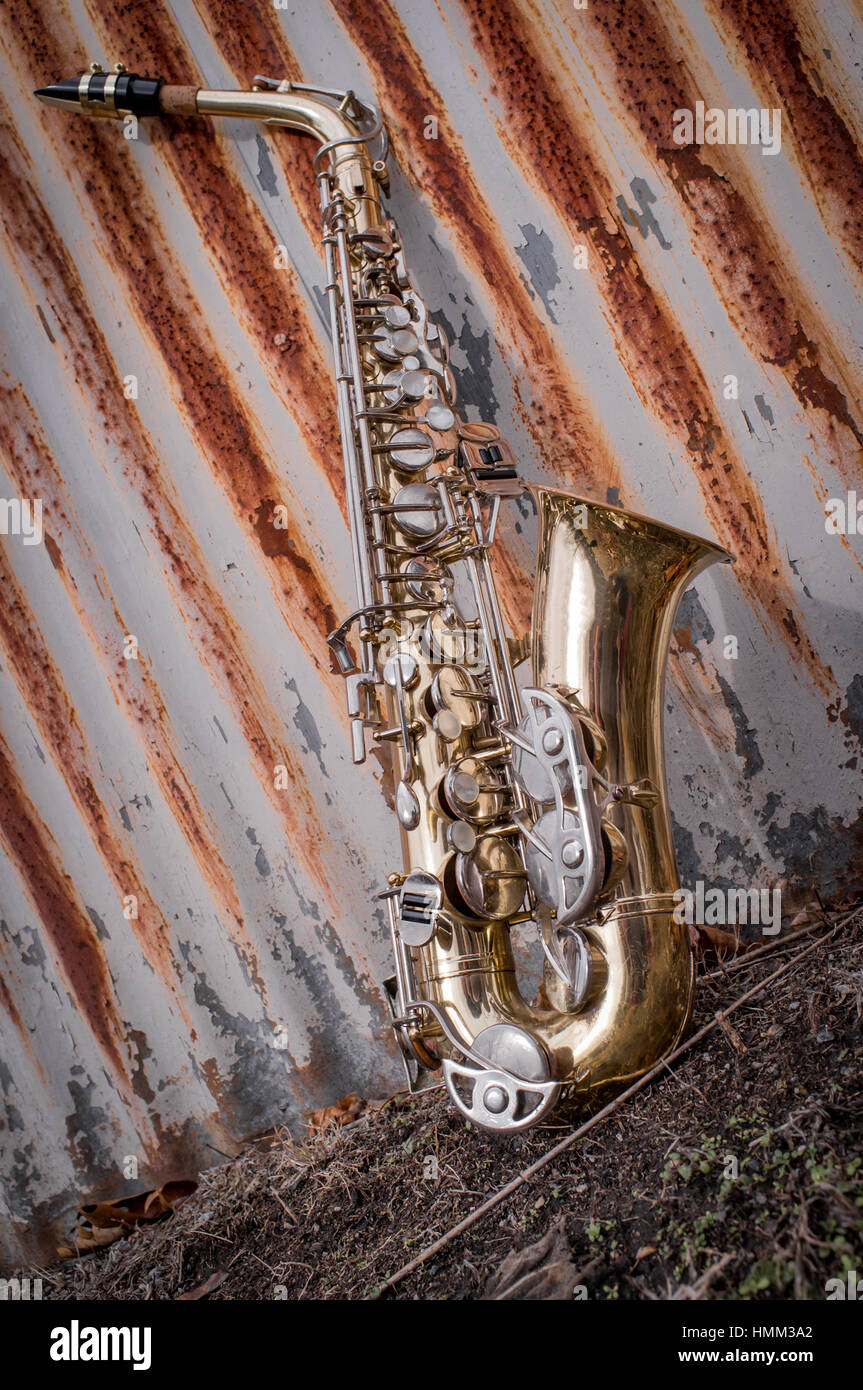 Jazz musical instrument saxophone with rusty fence background Stock