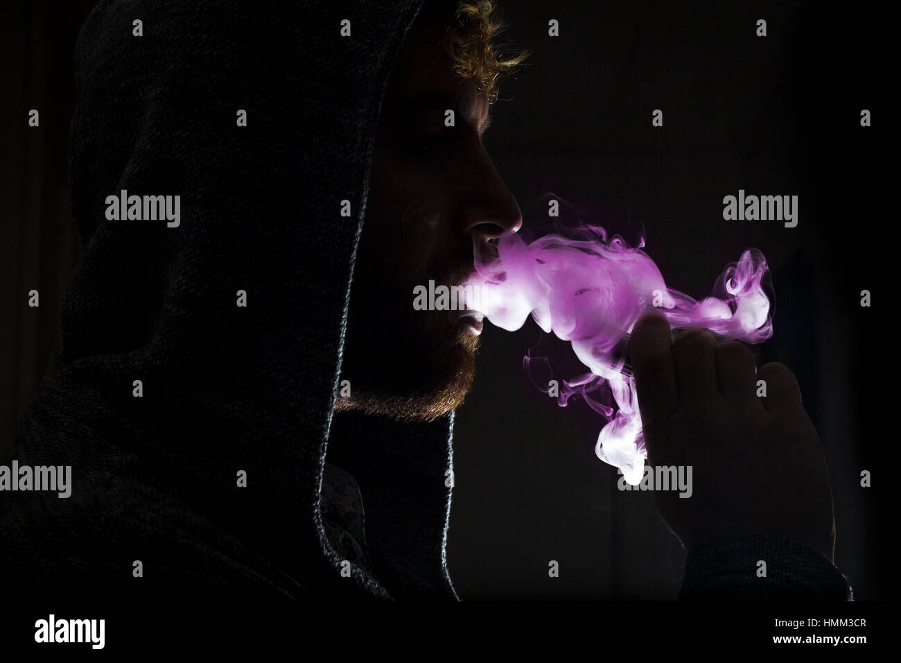 Vape Dramatic Dramatic lighting bearded man smokes a vape e-cigarette Stock Photo - Alamy