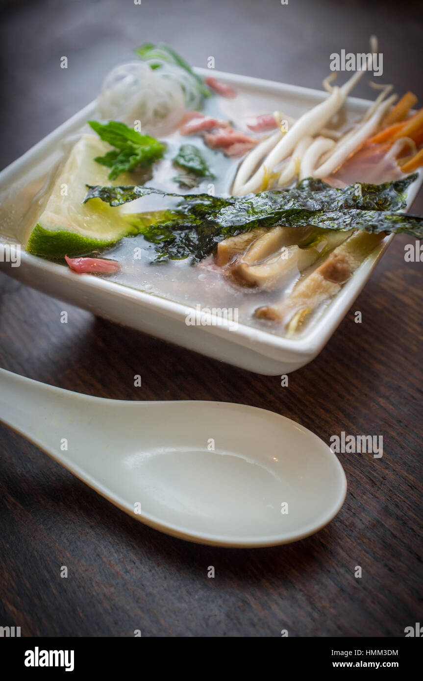 Traditional Vietnamese pho beef noodle soup garnished with mint leaves Stock Photo