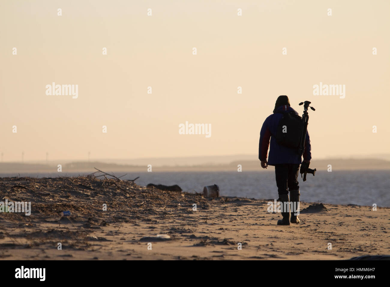 Silhouette of a photographer walking on the beach at Spurn Point, East Yorkshire, UK Stock Photo