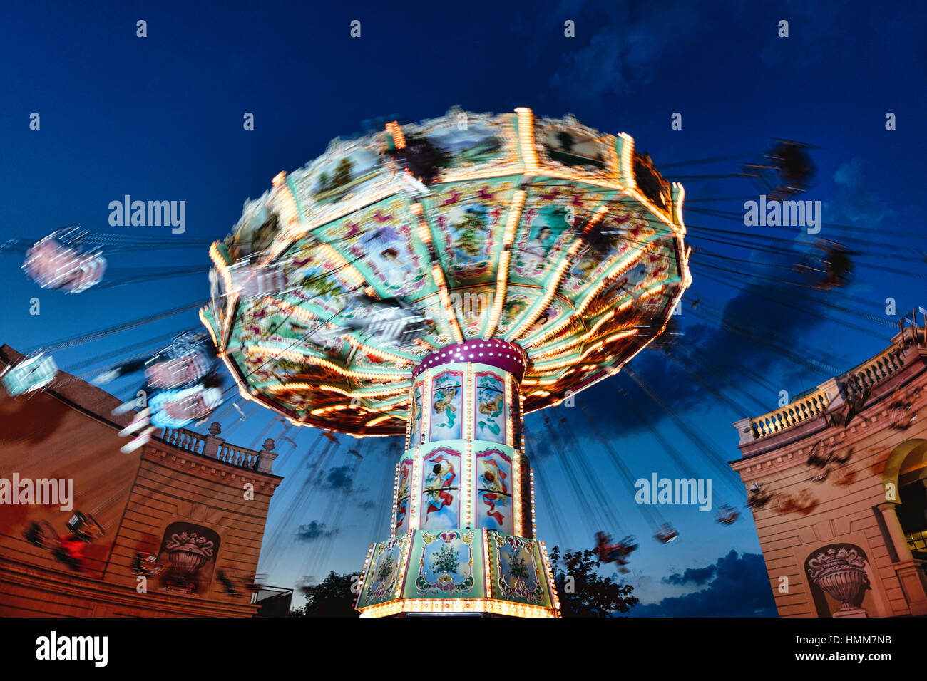 View of a Moving Chain Swing Ride at Dusk, Prater Amusement Park, Vienna, Austria Stock Photo