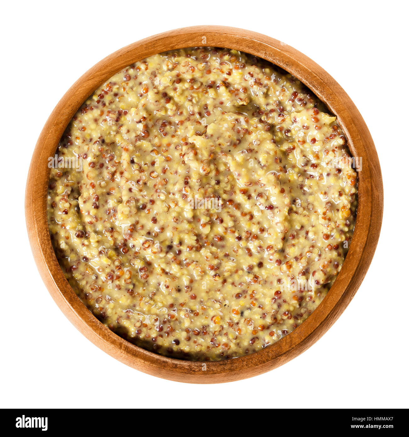 Whole grain Dijon mustard in wooden bowl with brown seeds. Traditional mustard named after the town of Dijon in Burgundy, France. Stock Photo