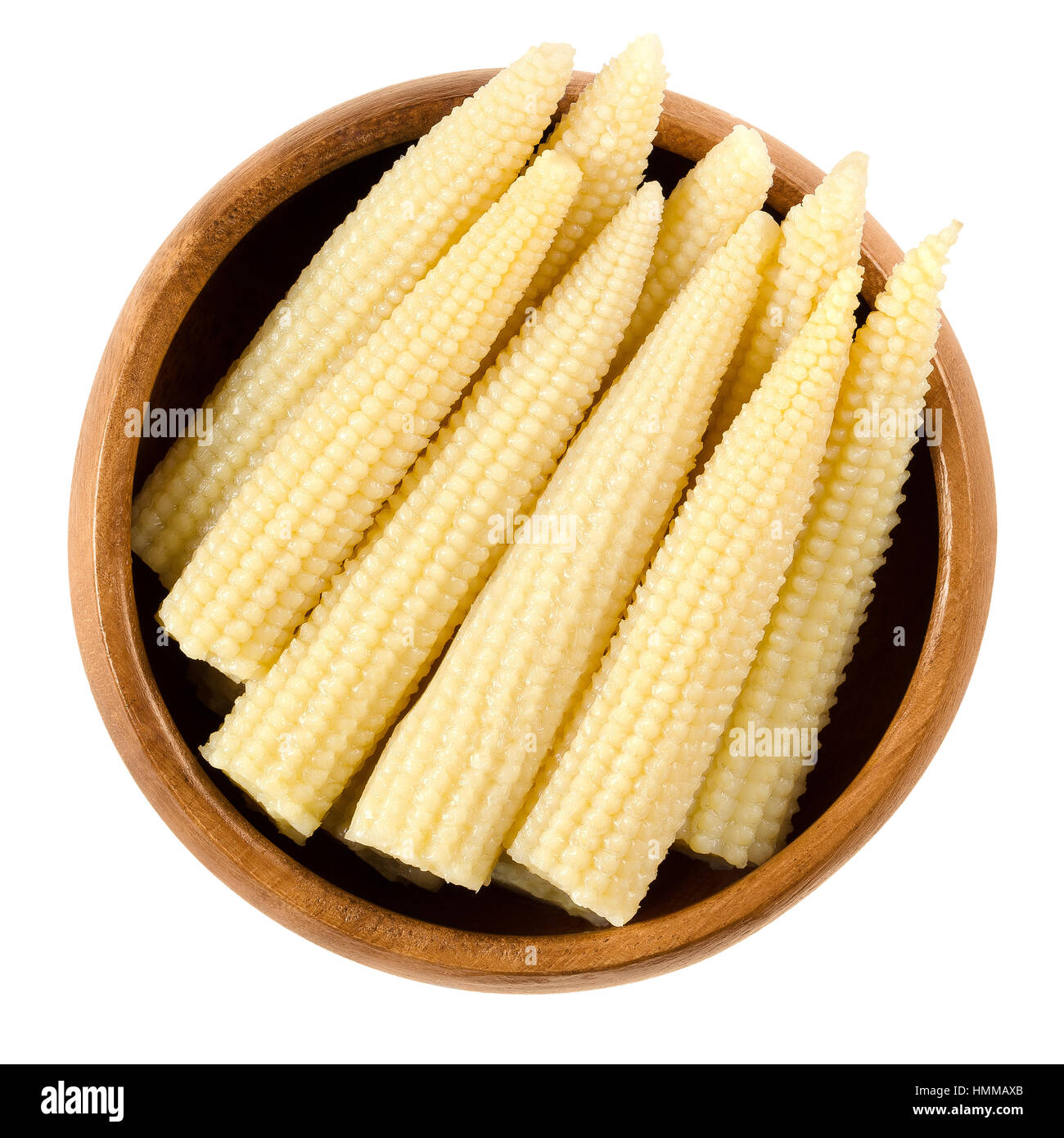Pickled whole baby corn in wooden bowl. Preserved small cooked corn with bright yellow color in a solution of vinegar and salt. Macro photo. Stock Photo