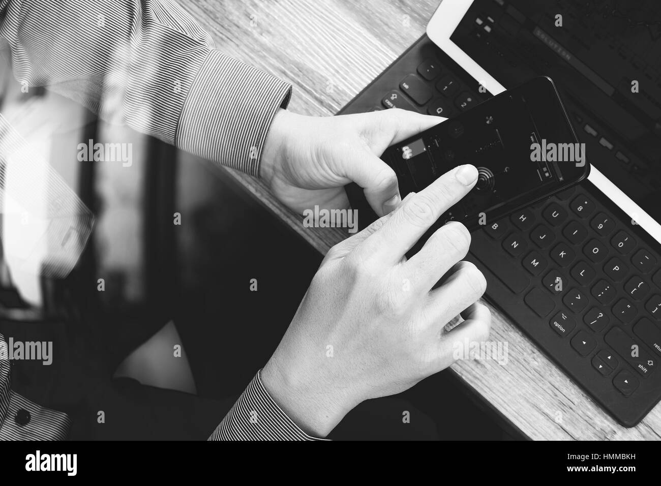 top view of businessman hand using smart phone,mobile payments online shopping,omni channel,digital tablet docking keyboard computer in modern office  Stock Photo