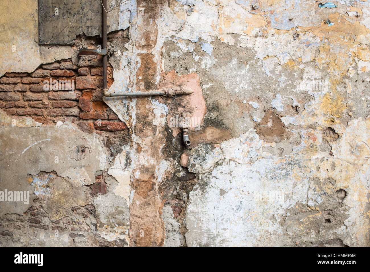 Drainage pipe protruding from dilapidated wall in Delhi Stock Photo