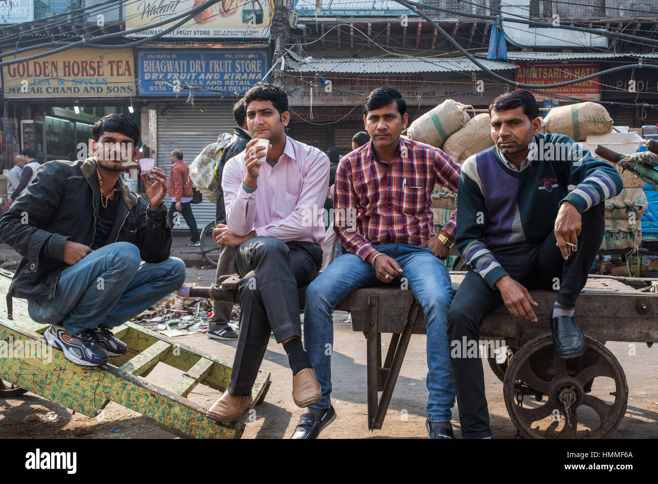 Four indian men  sat in the market place, old Delhi Stock Photo
