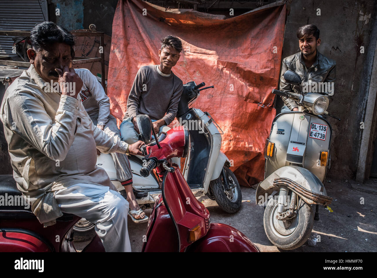 Three Indian men on motor scooters. Stock Photo