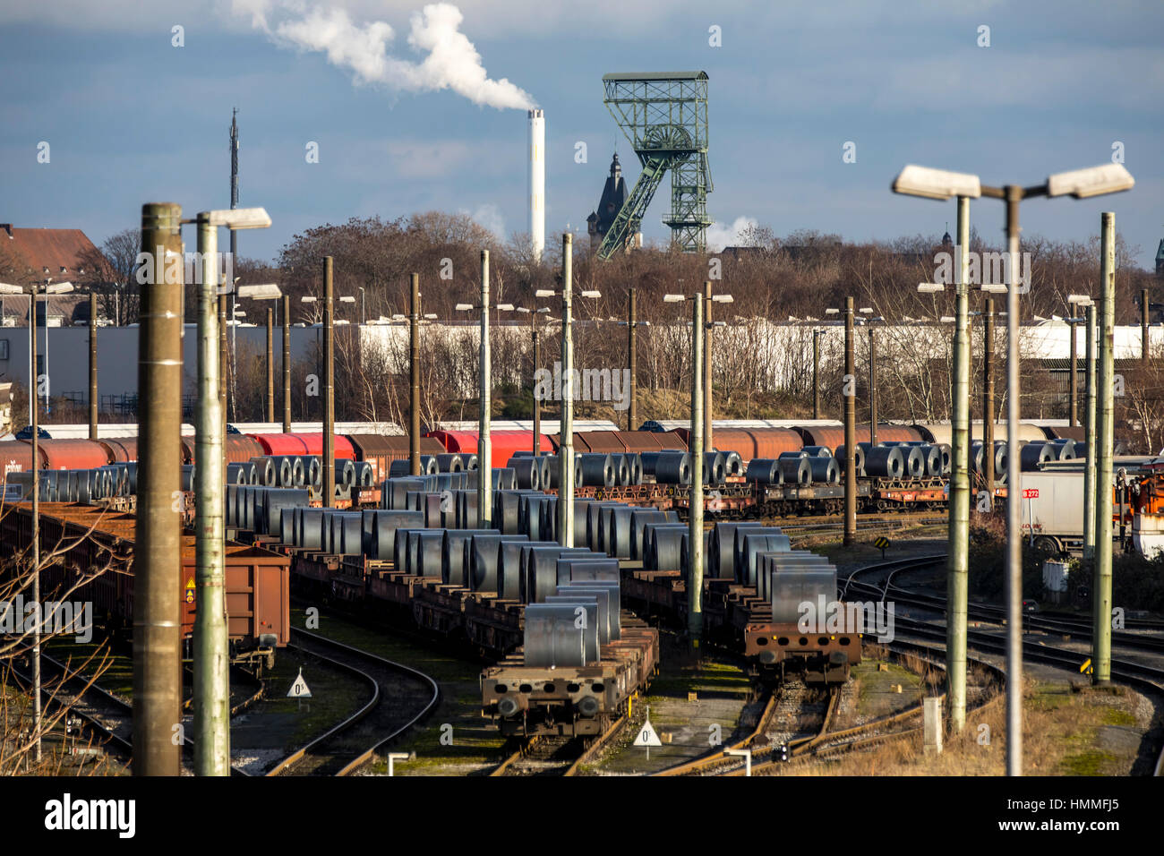 Freight station of ThyssenKrupp Stahlwerk, ThyssenKrupp Steel Europe AG steelworks, wagons with steel coils, winding tower of the former mine Thyssen  Stock Photo