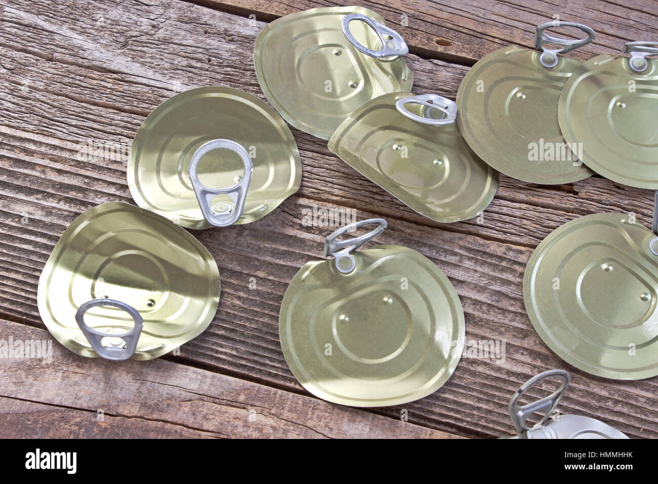 Tin can lids with opener on wooden background Stock Photo Alamy