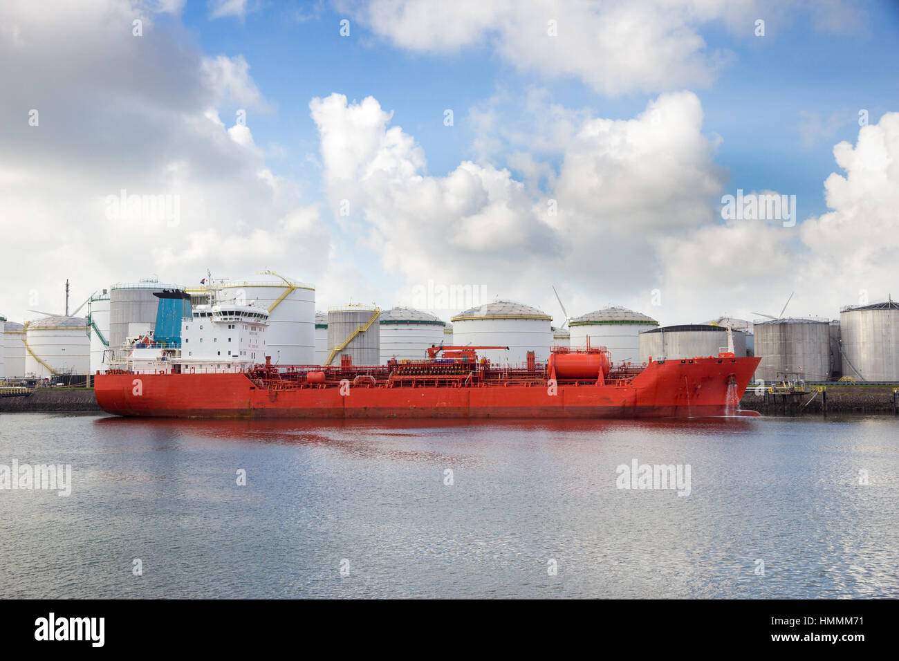 Red oil tanker moored at an oil terminal in a port Stock Photo