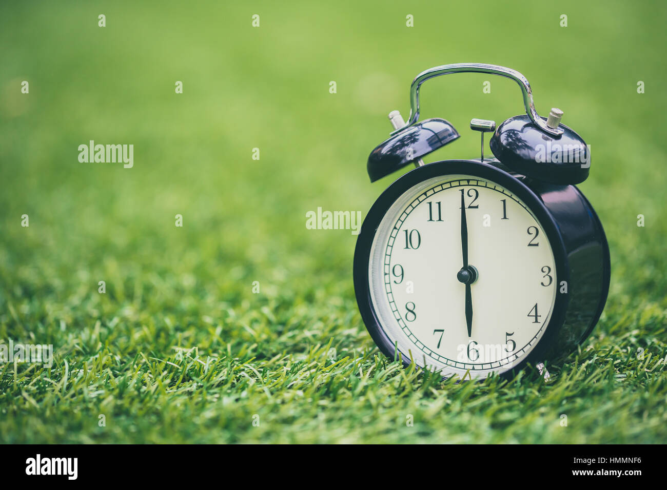 retro clock on green grass time at 6 o'clock Stock Photo Alamy