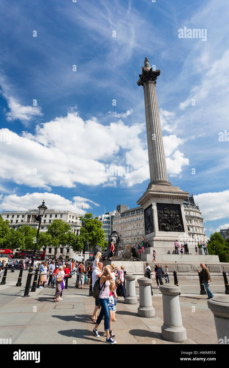LONDON - AUGUST 20: Nelson's Column at Trafalgar Square in London with blue sky and tourists passing by on August 20, 2013 Stock Photo