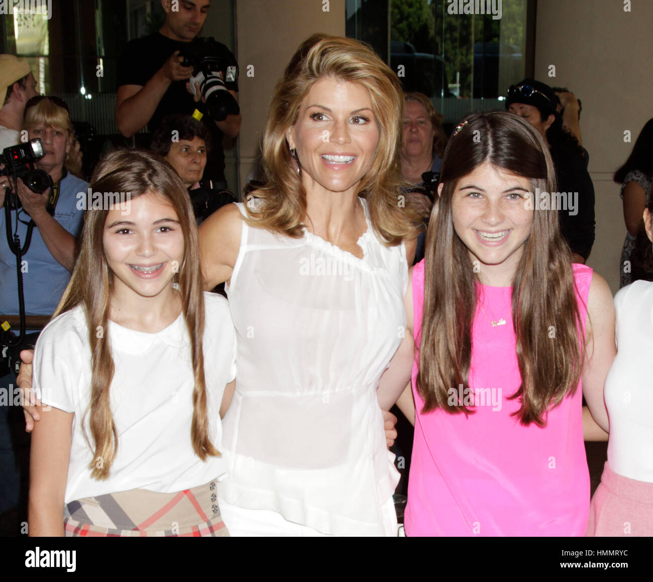 Lori Loughlin, center, with her daughters, Olivia Jade Giannulli, left, and Isabella Rose Giannulli arrive for the Hallmark Channel and Hallmark Movie Channel presentation at the 2013 Summer TV Critics Press Tour on July 24, 2013 in Beverly Hills, California. Photo by Francis Specker Stock Photo