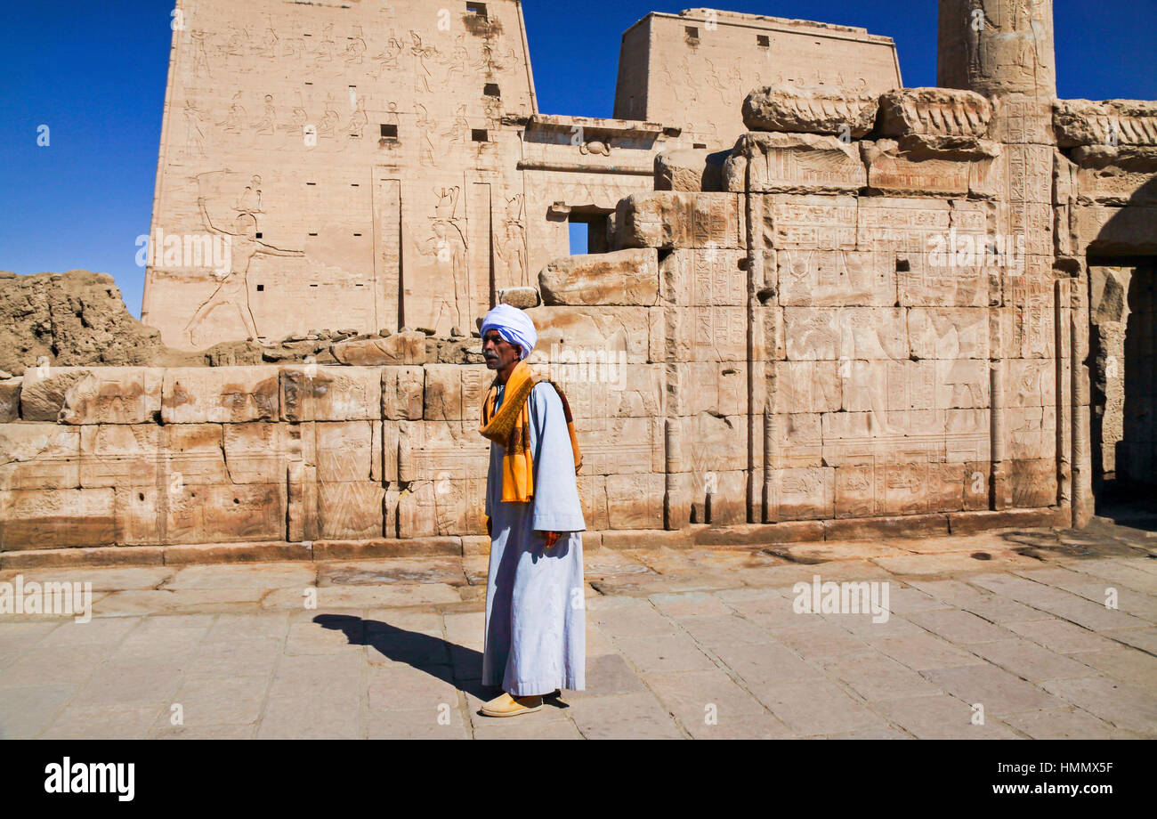 Local Old Man Person dressed in Traditional Nubian Clothing walking in ancient Egyptian Ruins in Temple of Philae Valley of the Kings in Luxor Egypt Stock Photo