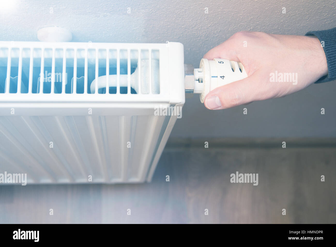 hand adjusting temperature on radiator Stock Photo