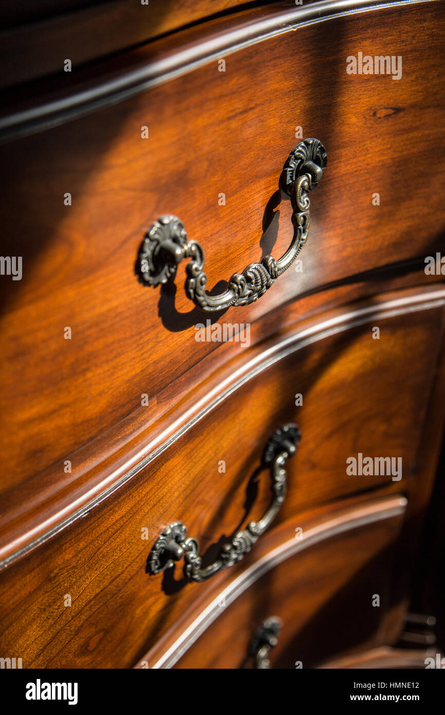 Wooden dresser drawers lit by natural window light. Stock Photo