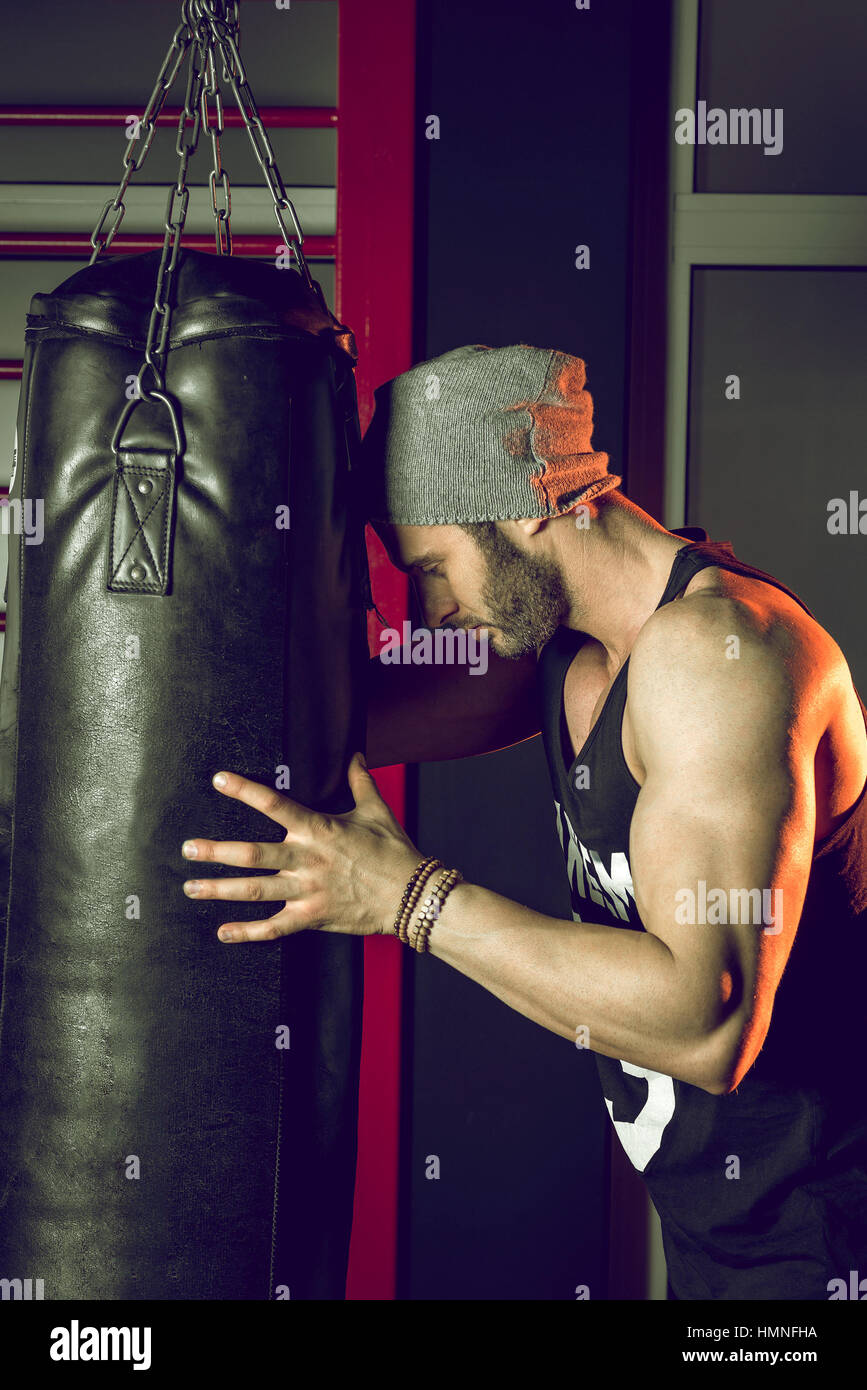 Man practicing boxing on big black bag in gym Stock Photo Alamy