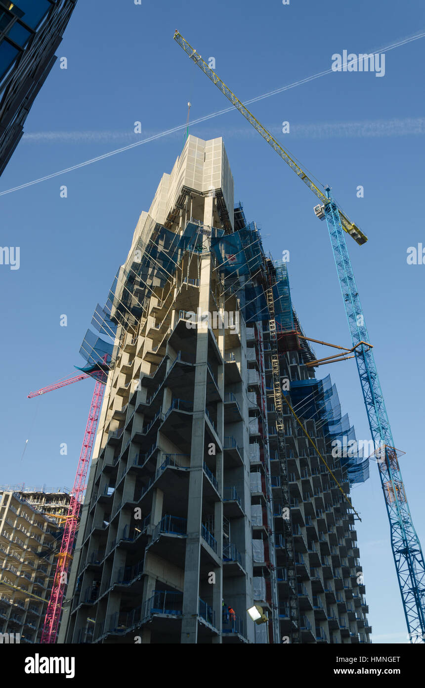 Towering cranes over the concrete skeleton of new skyscraper blocks as ...
