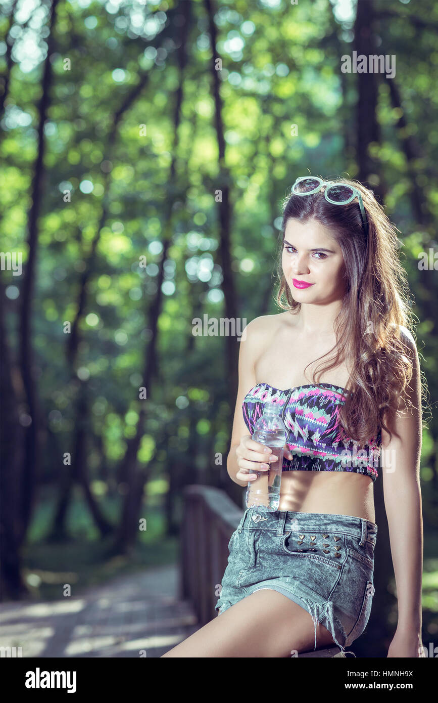 Young adult fit teen girl drinking fresh water from plastic bottle Stock Photo