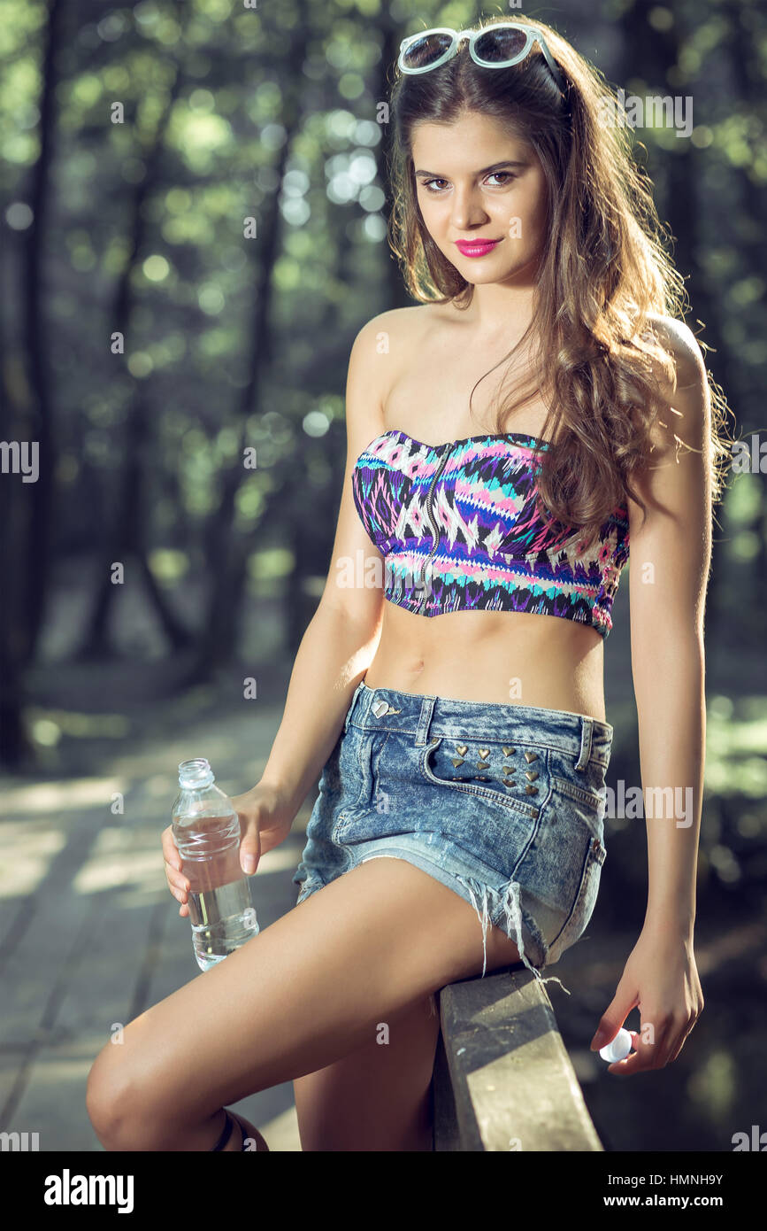 Young adult fit teen girl drinking fresh water from plastic bottle Stock Photo
