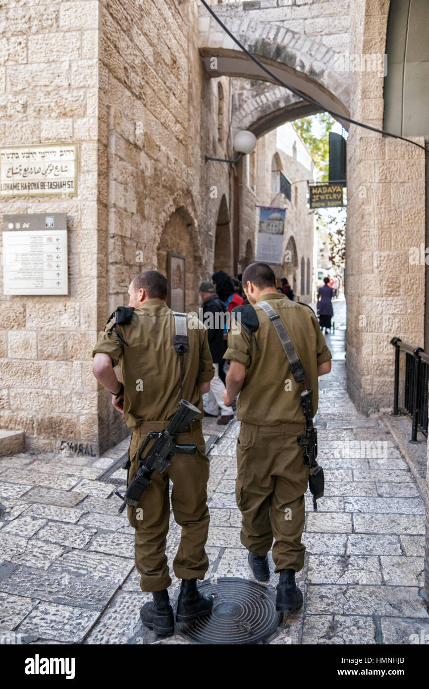 JERUSALEM, ISRAEL - JAN 23, 2011: Two armed Israeli soldiers walking through one of the many alleys in the Old City of Jerusalem. Stock Photo