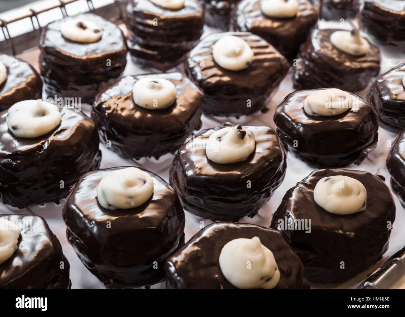 Delicious bakery display of cream filled chocolate frosted donuts Stock