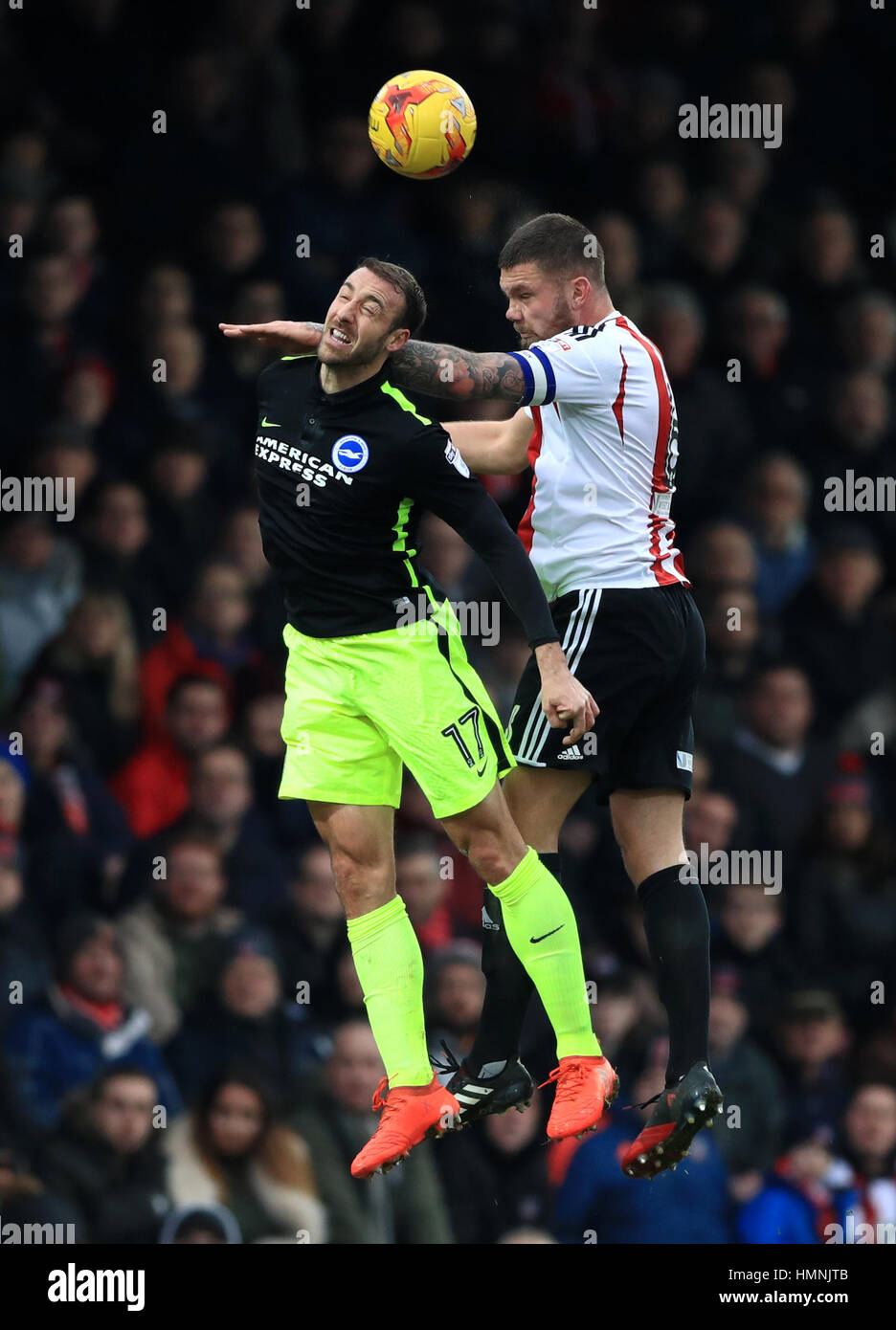 Brighton & Hove Albion's Glenn Murra (left) battles for possession of the ball in the air with Brentford's Harlee Dean (right) during the Sky Bet Championship match at Griffin Park, London. Stock Photo