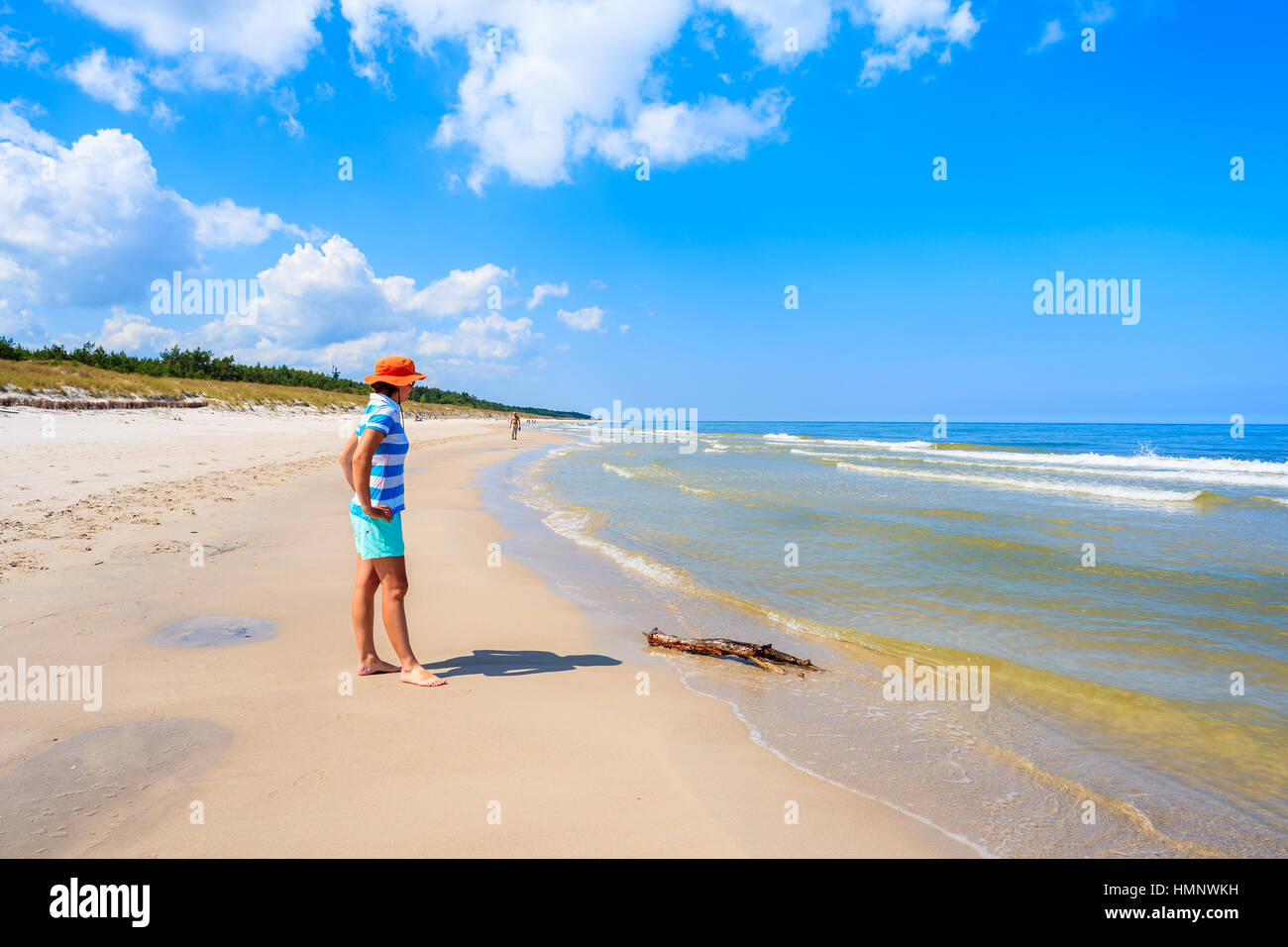 Young woman tourist standing on beautiful Lubiatowo beach on coast of Baltic Sea, Poland Stock Photo