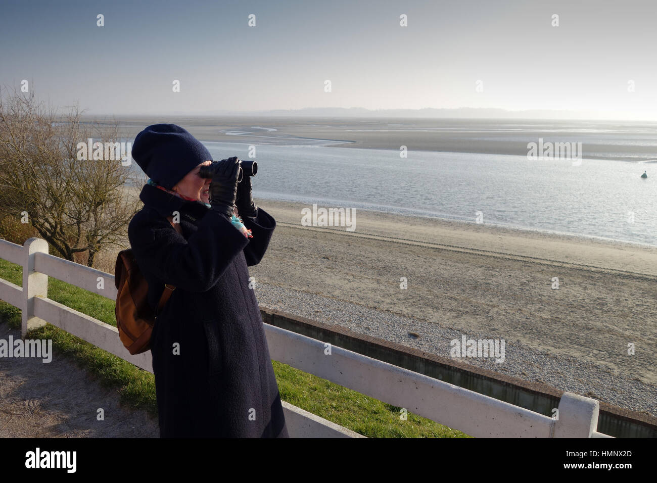 Le Crotoy in Northern France Baie de Somme estuary woman with binoculars Stock Photo