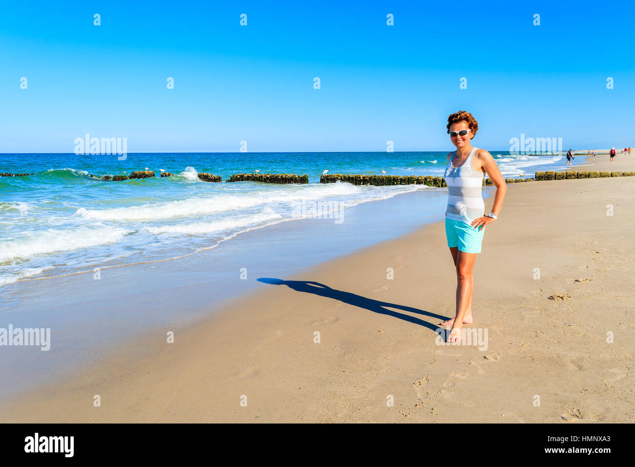 Young attractive woman standing on sandy beach, Sylt island, Germany Stock Photo