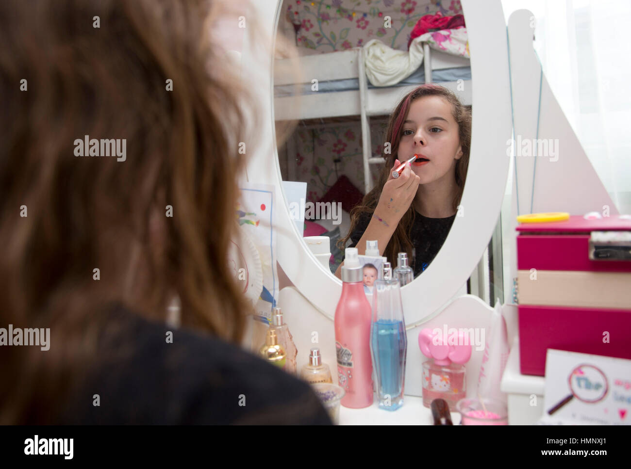 Teen girl putting on lipstick hi-res stock photography and images - Alamy