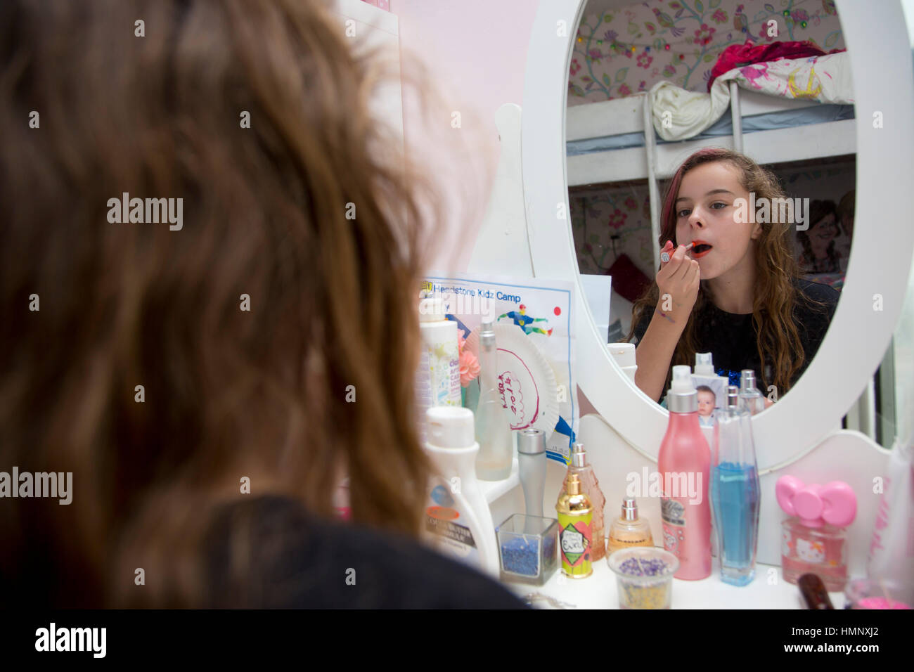 10 year old girl putting on makeup Stock Photo