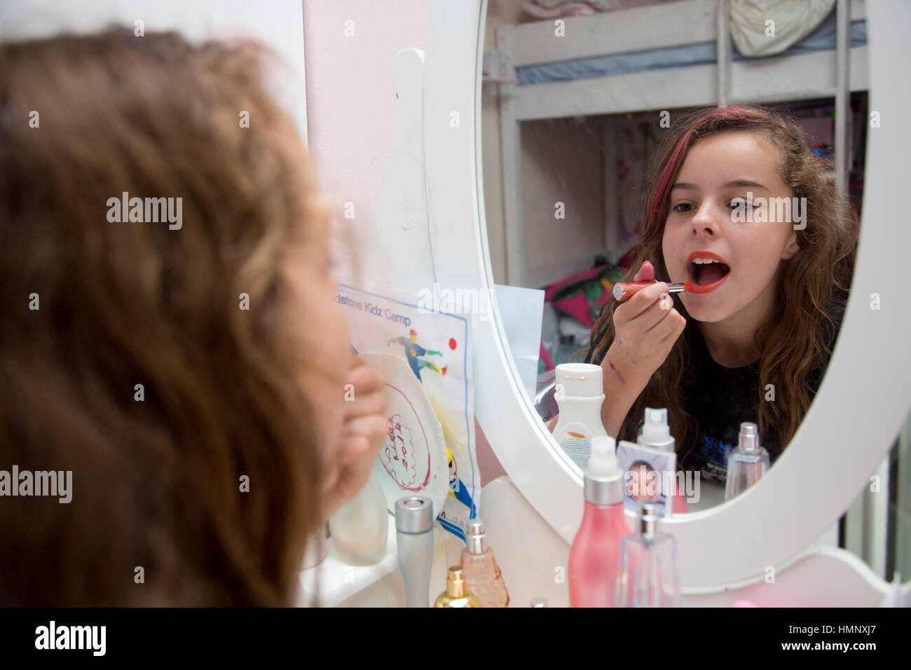 10 year old girl putting on makeup Stock Photo