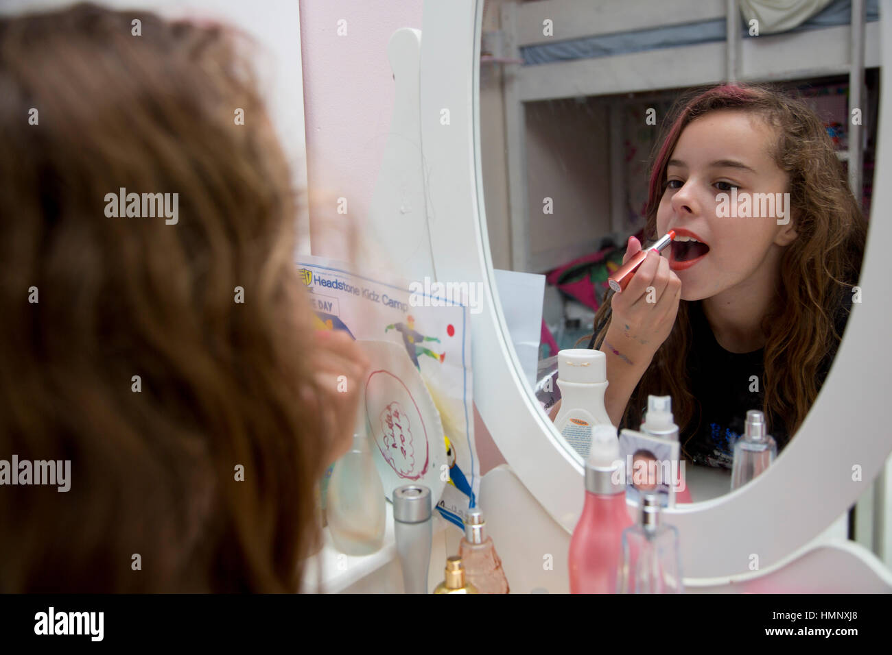 10 year old girl putting on makeup Stock Photo