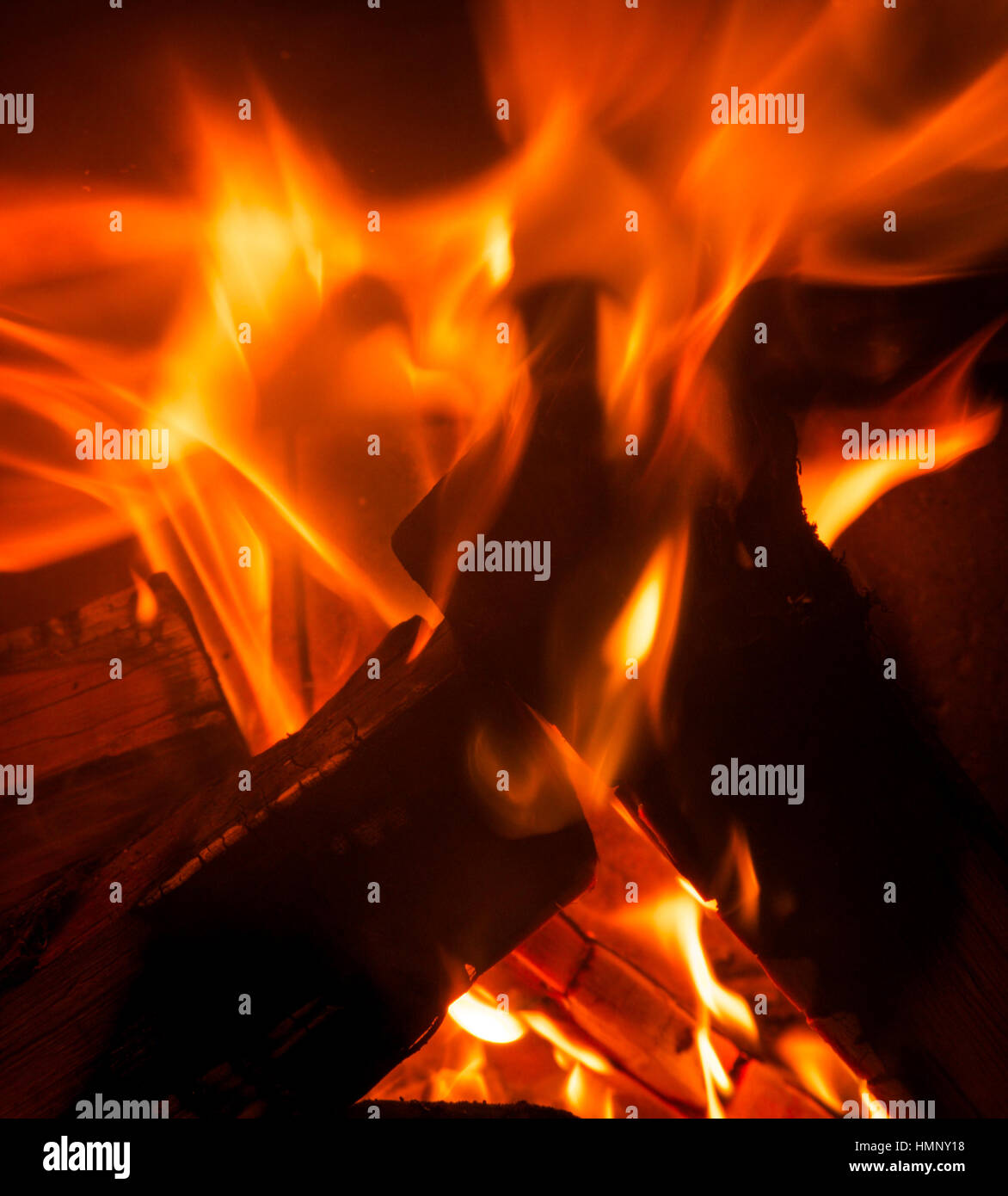 close up of orange and red flames burning on a fire with logs Stock Photo