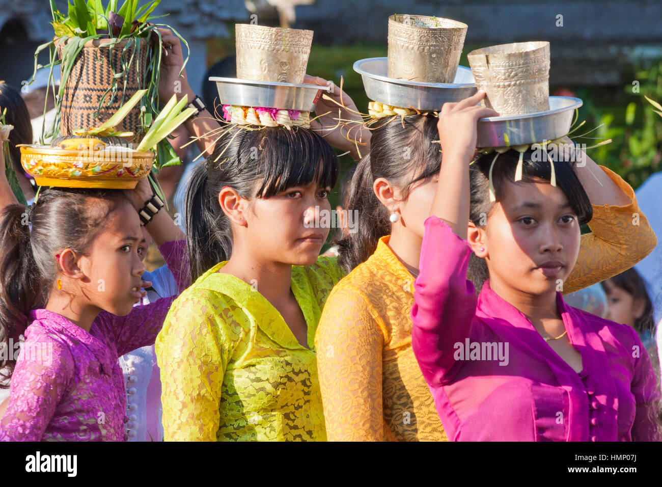 Young girls carrying offerings on their heads at the temple during the Galungan festival Stock Photo
