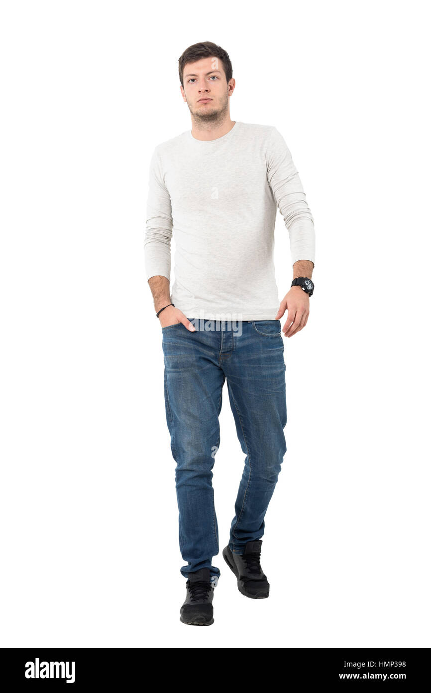 Confident young stylish man walking towards camera leisurely. Full body length portrait isolated over white studio background. Stock Photo