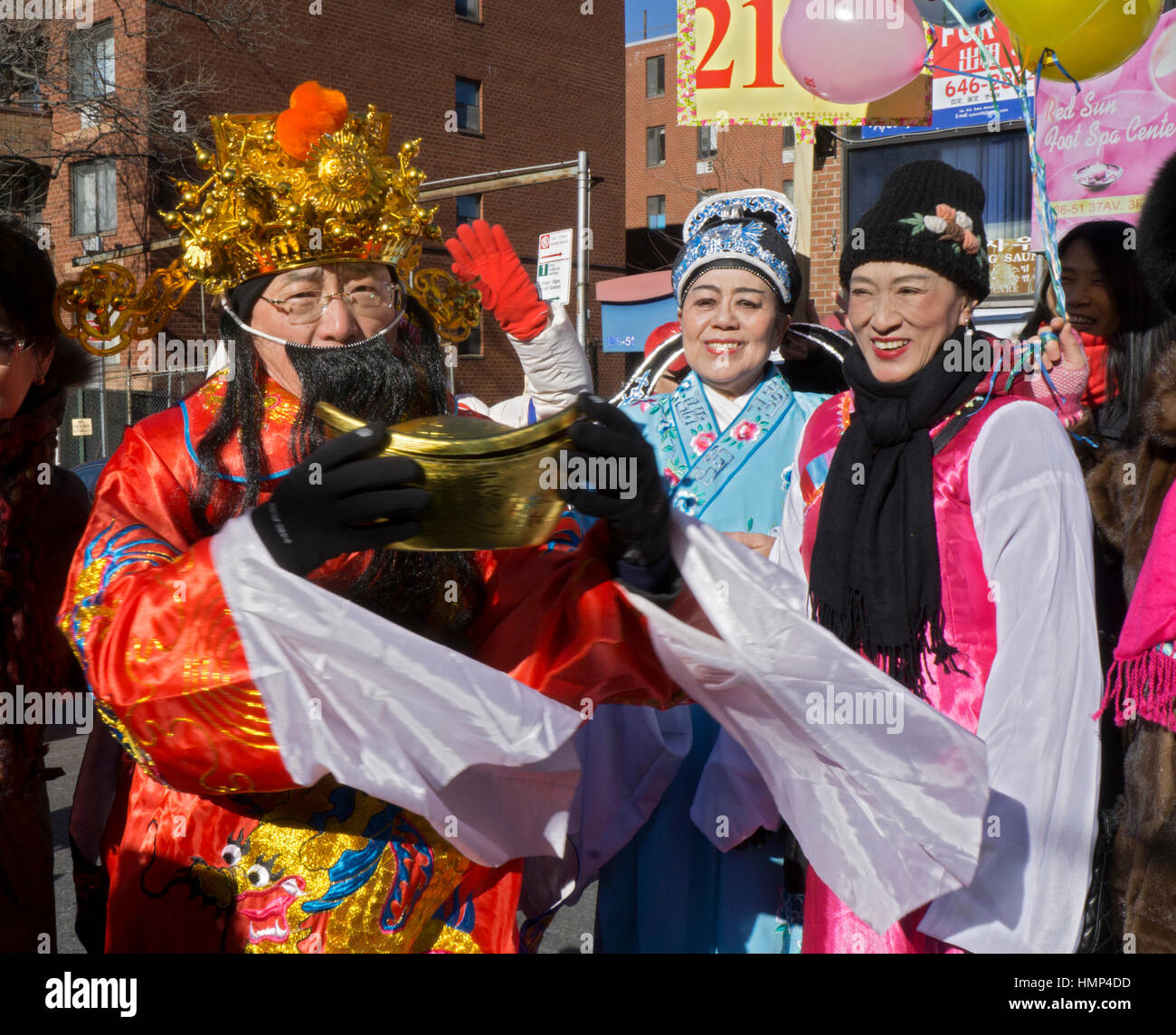 Three people in colorful costumes at the Chinese New Years Day Parade in Chinatown, downtown Flushing, New York City. Stock Photo