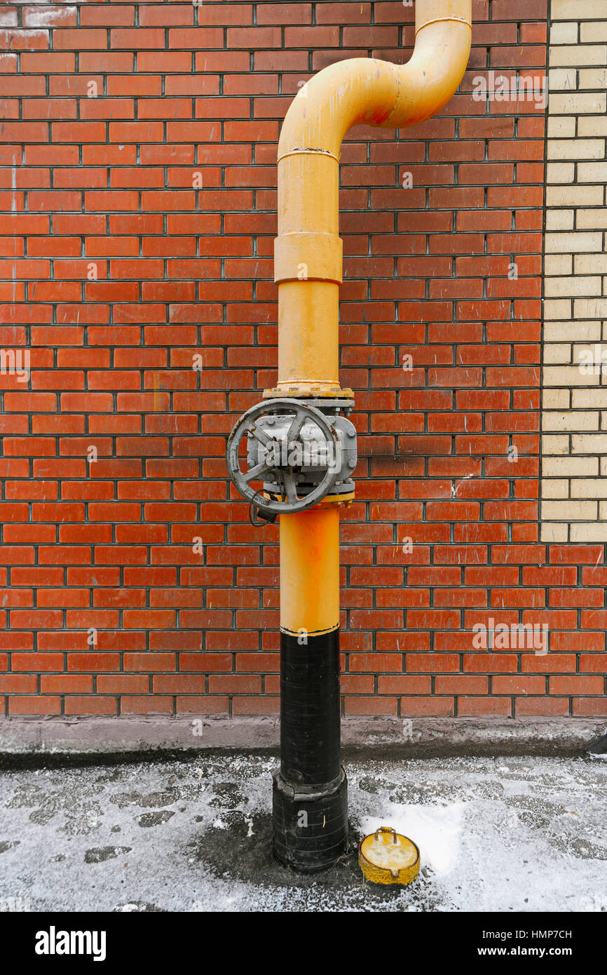 Natural gas system valve and pipe painted in yellow color in front of