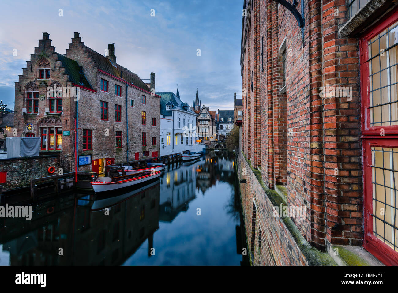 Buildings in central Bruges, Belgium, reflected in the canal in the morning twilight. Taken from Blinde-Ezelstraat at the back of Gotische Zaal Museum. Stock Photo