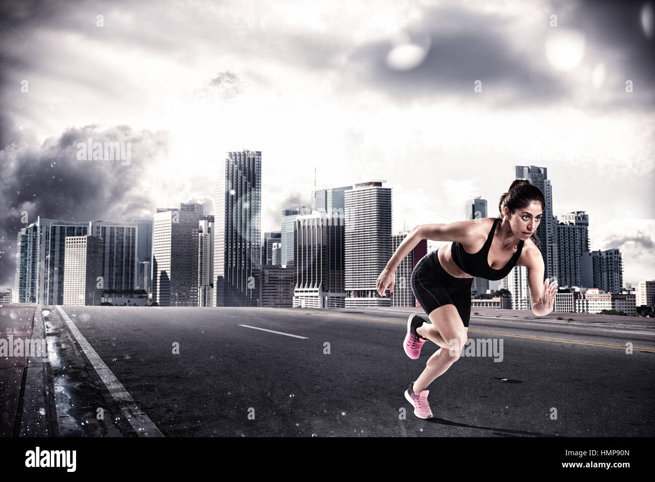 Athletic woman runner on the asphalt of a city road Stock Photo