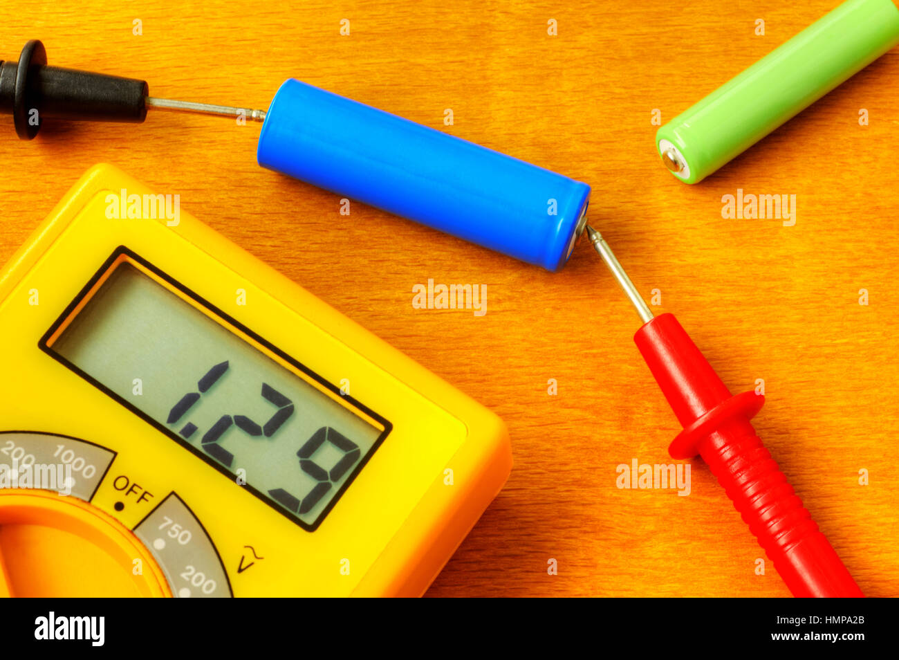 Measuring with digital multimeter of rechargeable battery Stock Photo